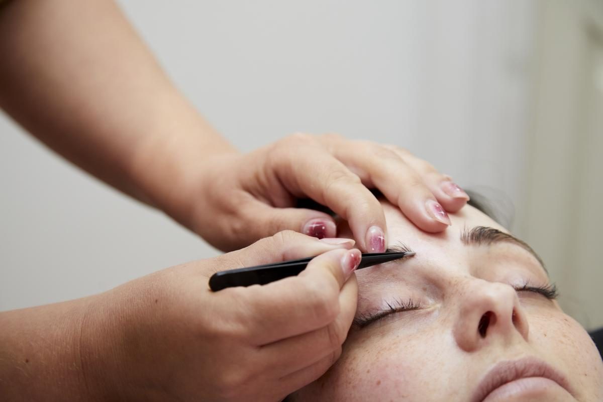 Alex shaping a client's brows